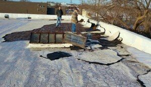 Joe Taylor (R) inspecting roof damage with assistant, David (L)